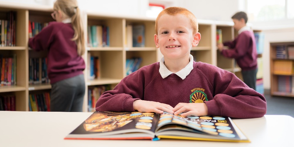 A Whitecliffe Academy student reads a history book in the library.
